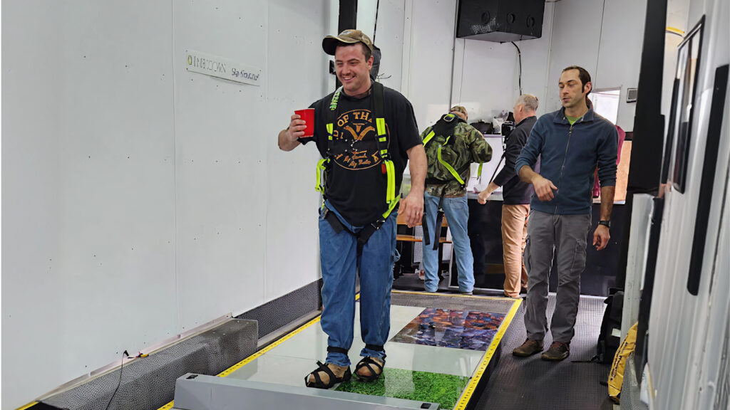 Man walking on Slip Simulator with trainer beside him